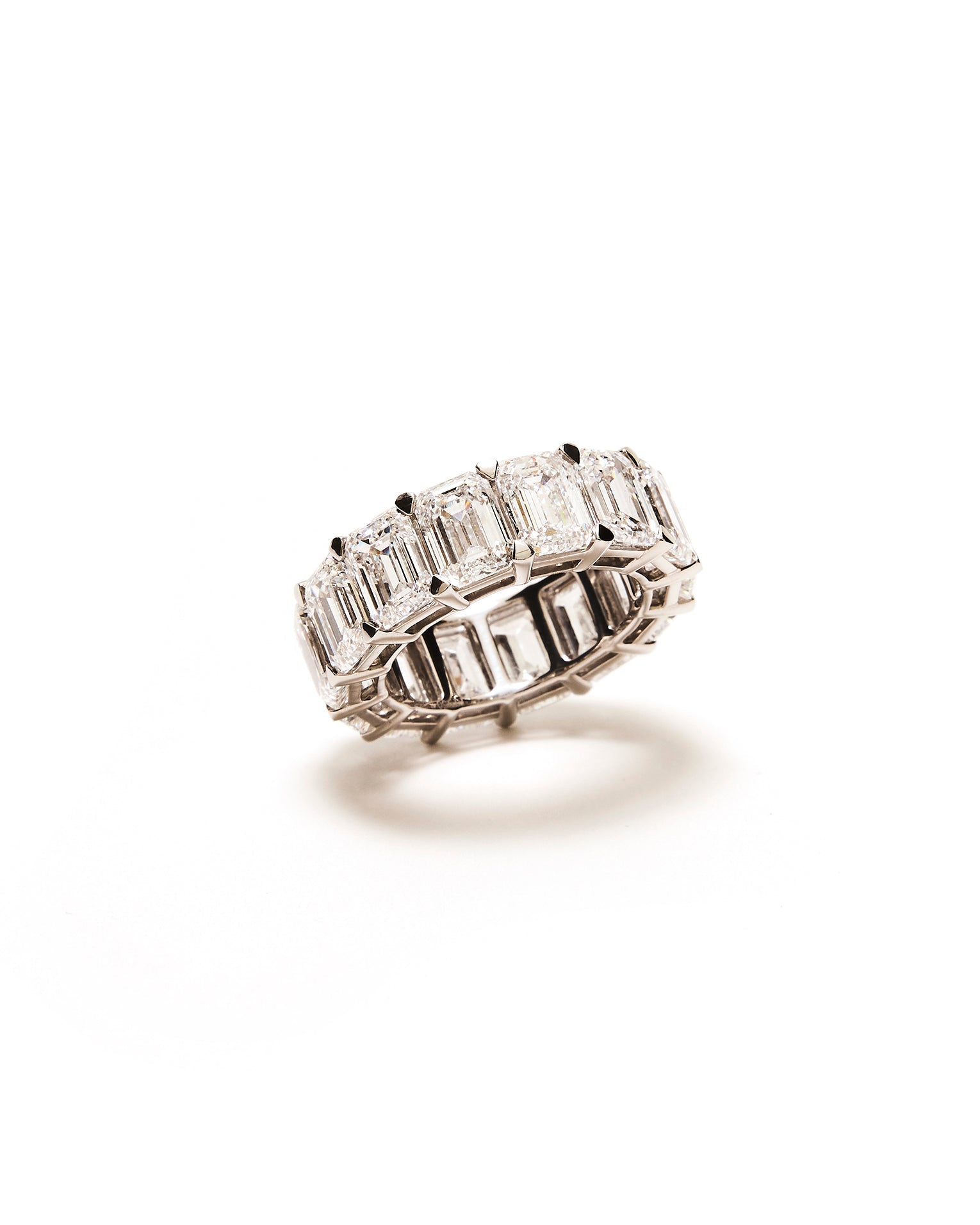 Diamond emerald eternity band square stones on a white background