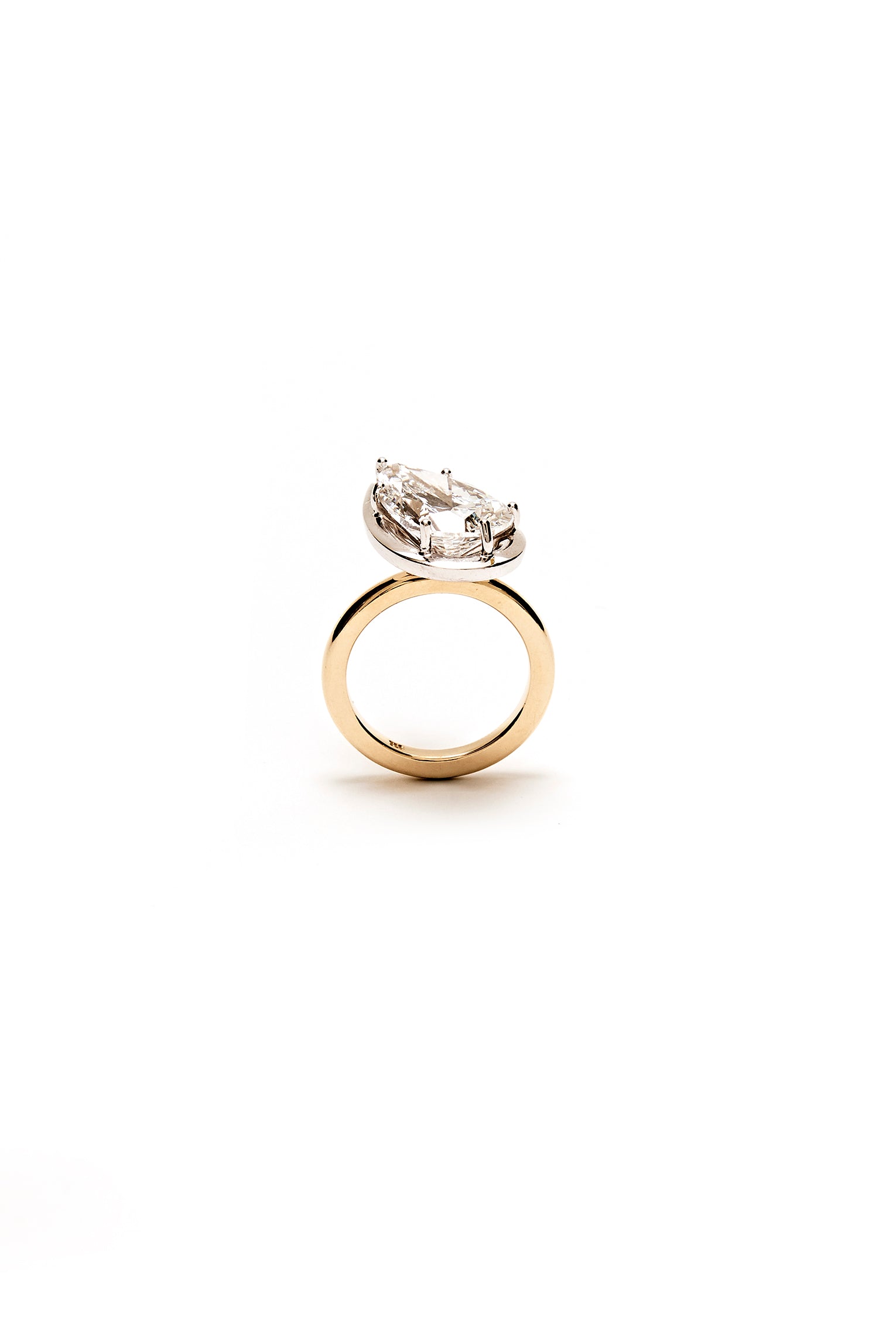 Gold ring with a pear-shaped diamond on a white background