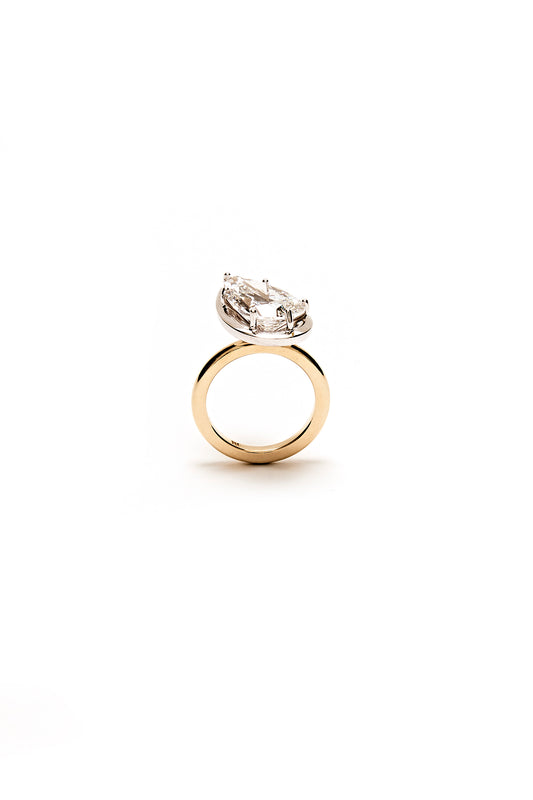 Gold ring with a pear-shaped diamond on a white background